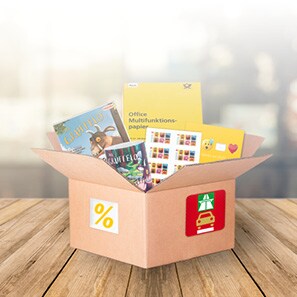 Karton gefüllt mit Briefmarkenbögen, Tassen, Kinderbüchern und Kopierpapier.